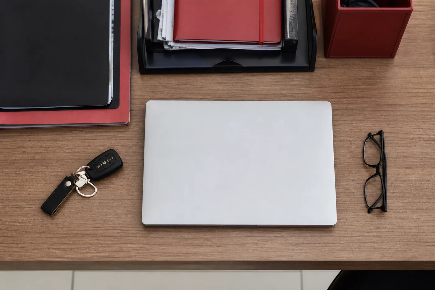 Mesa de trabalho do Máximo Despachante com pastas de documentos de veículos, chave de carro e notebook